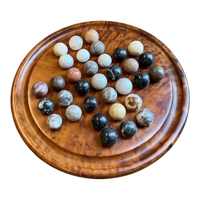 Lot 396 - Burr wood solitaire board, housing a collection of 33 assorted polished hardstone marbles.