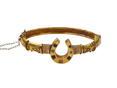 Lot 1001 - Victorian 9ct gold hinged bangle with a central horse shoe set with sapphires and rose cut diamonds