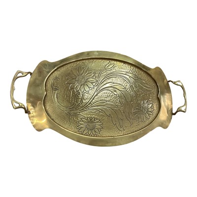 Lot 387 - Early 20th century Arts and Crafts brass tray of oval form, with engraved decoration of sun flowers, 47.5cm in length.