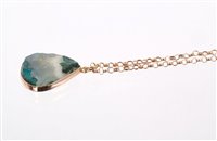 Lot 547 - Un-cut emerald in rose gold mount on rose gold...