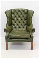 Lot 1202 - Leather upholstered wing armchair, green...