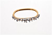 Lot 524 - Sapphire and diamond hinged bangle with a...