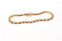 Lot 527 - Ruby and diamond bracelet with a line of round...
