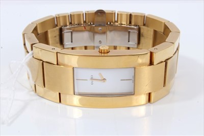Lot 3262 - Gucci gilt stainless steel wristwatch with rectangular white dial, numbered 0011200, boxed