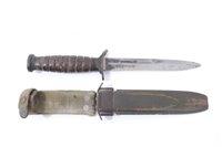 Lot 811 - Second World War American M3 Fighting Knife with ribbed wooden grip and steel blade stamped 'US M3 Camillus' in its fibre scabbard with webbing frog.
