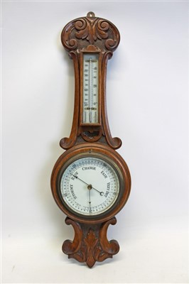 Lot 3505 - Early 20th century aneroid barometer with 5 inch circular dial and separate thermometer in a carved oak case, 60cm overall length
