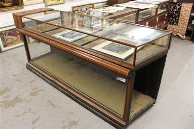 Lot 880 - Early 20th century shop counter, with angled end, the glazed top with three rear hinged doors, the glazed base with panelled back, 224cm wide x 60cm deep x 101cm high