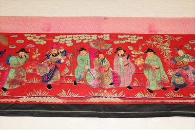 Lot 3054 - Chinese embroidered red silk banner. Silk satin stitch with crouched outlines, figures have painted silk faces, Wiseman in sedan chair, dancers and deities in garden scene. Printed cotton lining