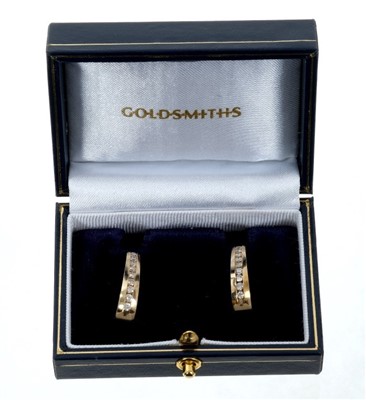 Lot 87 - Pair of  14ct gold and diamond hoop earrings, each with a line of channel set brilliant cut diamonds estimated to weigh approximately 1 carat in total. 21mm
