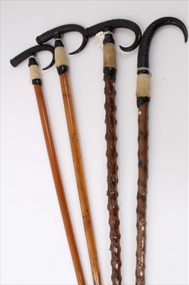 Lot 3667 - Four Alpine walking sticks with Ibex horn handles and spiked ferrules, one inscribed "Interlaken" and another "Rigi-Kulm Pilatus Tomlishoon Furka Rohne Glacier etc". All four approximately 94cm ov...