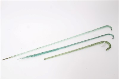 Lot 3665 - Two late 19th/early 20th century twisted green glass "frigger" walking sticks together with another short "frigger" walking stick (lower end missing) longer sticks 93cm and 76cm overall length, sho...