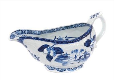Lot 7 - 18th century Derby blue and white sauceboat, circa 1760, moulded with pears and flowers and scrolled reserves, painted with fishermen under willow trees with Chinese pagodas, 20cm length