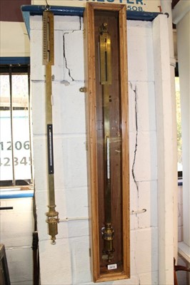 Lot 3814 - Mid 20th century brass cased stick barometer by W & J George & Becker Ltd, suspended in a pine hanging display case with glazed door, barometer 101cm long, together with another similar example, 10...