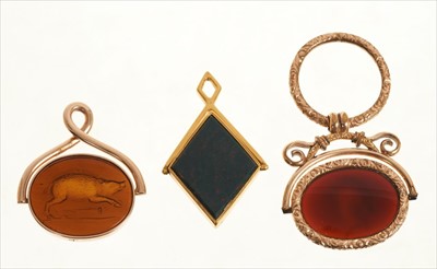 Lot 421 - 19th century oval glass intaglio depicting a wild boar jumping over a torch in 9ct gold mount, a later oval agate intaglio depicting side profile bust of a Roman soldier in engraved gilt metal moun...