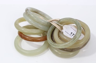 Lot 173 - Ten jade/green hard stone polished bangles