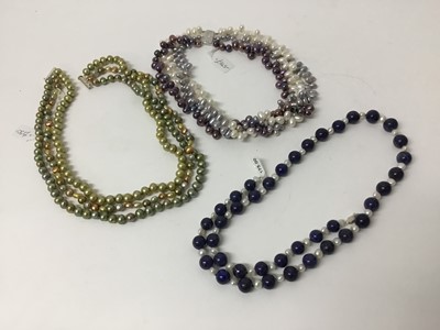 Lot 216 - Freshwater cultured pearl three strand choker necklace with purple, grey and whiter cultured pearls on a silver clasp, 42cm, together with a three strand green freshwater cultured pearl necklace wi...