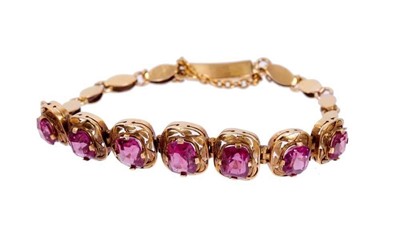Lot 468 - Gold and garnet bracelet with seven graduated mixed cut garnets in pierced gold setting