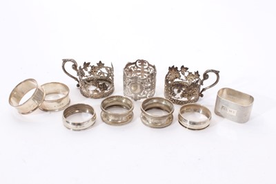 Lot 311 - Eight assorted silver napkin rings, together with a pair of silver cup holders (Various dates and makers) All at approximately 6ozs. (10)
