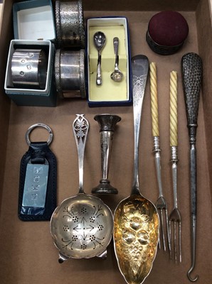 Lot 705 - Three silver napkin rings, silver tea strainer, silver berry spoon and other silverware