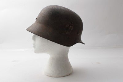Lot 689 - Second World War Nazi M35 pattern Waffen SS steel helmet, with metal headband, leather chin strap, battle damage to the top of the helmet, painted SS insignia, named to Grohmann under the brim.