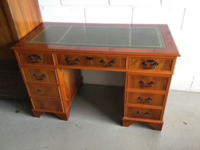 Lot 51 - Reproduction yew wood twin pedestal desk with green leather top and an arrangement of eight drawers below on bracket feet together with a similar desk chair