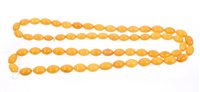 Lot 759 - Amber necklace with a long string of oval...