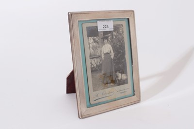 Lot 224 - Contemporary silver photograph frame of rectangular form with reeded decoration and beaded borders with easel support to rear, import marks for London 1984, 21 x 16cm