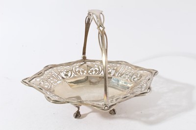 Lot 56 - Good quality Edwardian silver cake basket of oval form with faceted and pierced decoration and swing handle, raised on four claw and ball feet (London 1906)