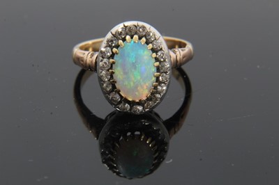 Lot 21 - Antique opal and diamond cluster ring with an oval cabochon opal surrounded by nineteen old cut diamonds in silver collet setting with pierced gold gallery on gold shank
