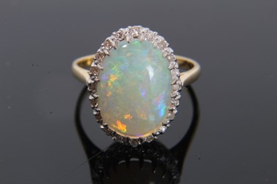 Lot 24 - Opal and diamond cluster ring with an oval cabochon opal surrounded by 20 single cut diamonds on 18ct gold shank