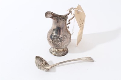 Lot 36 - George III Irish silver cream jug with repousse cattle in landscape panels, scroll handle and circular pedestal foot (Dublin 1792), together with a George IV Irish silver cream ladle (Dublin 1826),...