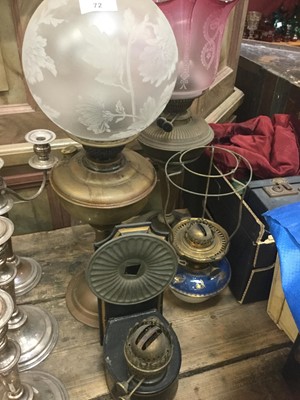 Lot 72 - Two Edwardian brass oil lamps, one with cranberry glass shade the other etched, together with a Copeland reservoir and one other oil lamp (4)