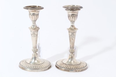 Lot 37 - Pair of Victorian silver candlesticks with fluted tapering stems, urn-shaped candle holder with separate sconces, on fluted and reeded oval bases, (London 1895), 19cm in overall height