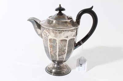 Lot 31 - George V silver hot water jug of tapered form with faceted decoration, ebony finial and loop handle, raised on circular foot, (Sheffield 1931) maker Viners Ltd