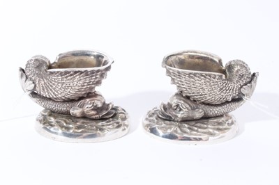Lot 13 - Pair of 19th century cast white metal salts  in the form of a nautilus shell on the back of a dolphin, on a wave pattern oval base, possibly an Elkington electrotype, 9.5cm overall width