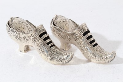 Lot 161 - Pair of late Victorian Continental silver Pot Pouri holders in the form of shoes with embossed decoration, hinged covers and gilded interiors with import marks (London 1900)