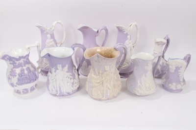 Lot 72 - Collection of nine 19th century relief moulded lilac-ground jugs, mostly Samuel Alcock, including the Portland Jug, Naomi and her Daughters in Law, etc, the largest measuring 29cm height
