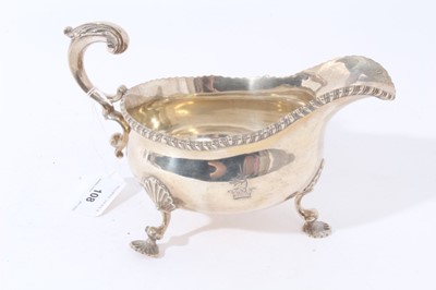 Lot 108 - Victorian silver sauce boat with gadrooned border on three scroll legs with shell feetLarge Victorian silver sauce boat of helmet form with engraved armorial, gadrooned border and scroll handle