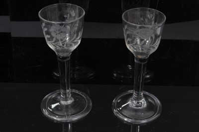 Lot 148 - Two Georgian wine glasses, c.1740, the ogee bowls engraved with flowers, with plain stems and folded conical feet, 14.5cm and 14.75cm height
