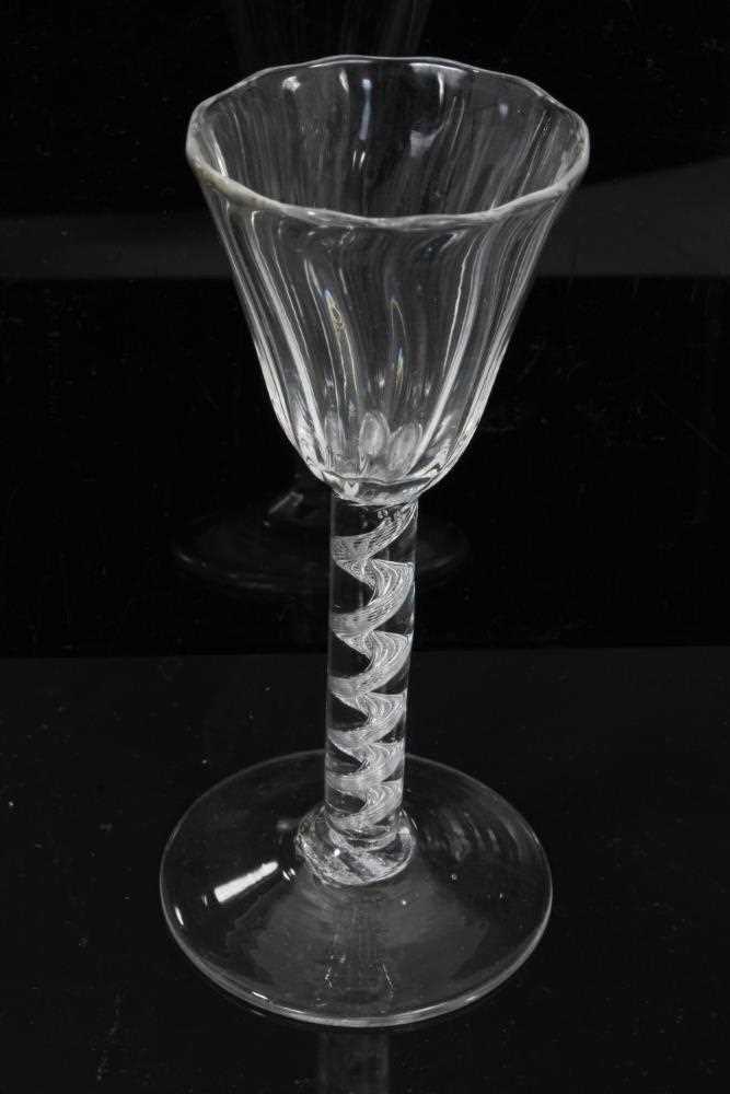 Lot 164 - Georgian air twist wine glass, c.1750, the pointed round funnel bowl with slightly wrythen vertical moulding, the stem with single spiral cable over a conical foot, 13.75cm height