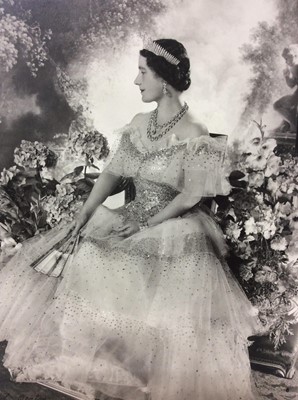 Lot 54 - H.M. Queen Elizabeth , fine 1939 Cecil Beaton black and white portrait photograph - The Queen wearing a beautiful sequinned ball gown and jewels with a painted classical garden scene backdrop, moun...