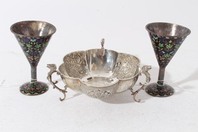 Lot 135 - George V silver dish with panels of embossed decoration, raised on three scroll feet with Bears head terminals, (Chester 1911), maker Jay, Richard Attenborough Co Ltd, together with a pair of white...