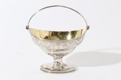 Lot 185 - George III silver sugar basket of navette form with brite cut engraved decoration, engraved armorial, swing handle with gilded interior, raised on oval pedestal foot, (London 1794), maker H S, all...