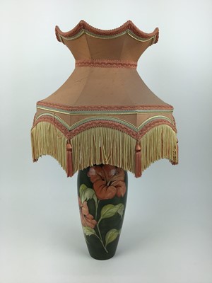 Lot 598 - Moorcroft pottery table lamp decorated in the Hibiscus pattern on green ground, impressed marks to base and original paper label - Potters To The Late Queen Mary, 31.5cm high excluding the fittings