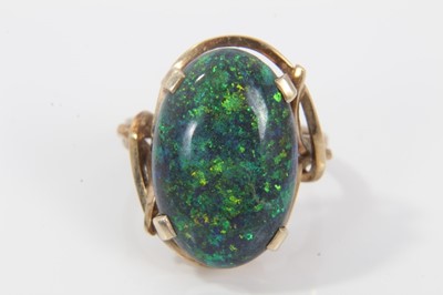 Lot 33 - Black opal single stone ring with an oval black opal cabochon measuring approximately 20mm x 13mm x 4.2mm in a 9ct gold setting. Ring size O.