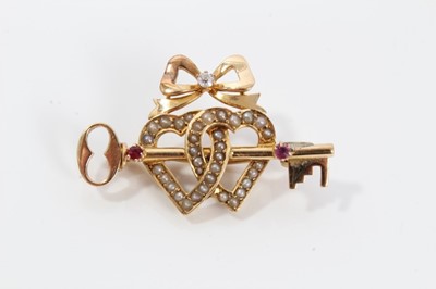 Lot 48 - Late Victorian 15ct gold diamond, ruby and seed pearl sweetheart brooch with a gold key and two interlocking hearts surmounted by a bow. 36mm
