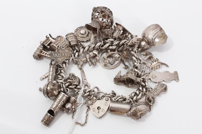 Lot 232 - Silver charm bracelet with a collection of silver and white metal charm and padlock clasp.