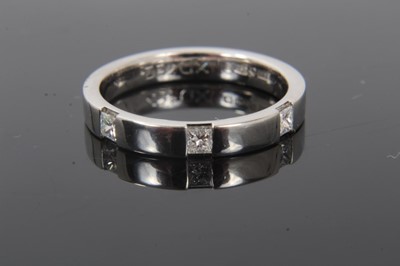 Lot 244 - Platinum and diamond half eternity style ring with three princess cut diamonds to the flat court shape platinum band. Ring size M½