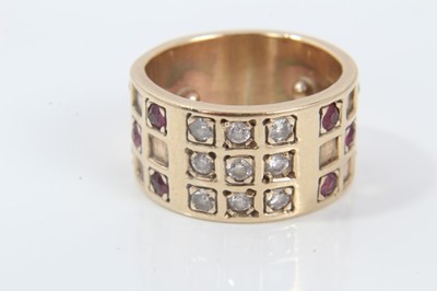 Lot 245 - Diamond and ruby ring with a wide 9ct yellow gold band with brilliant cut diamonds and mixed cut rubies in a grid-style setting.