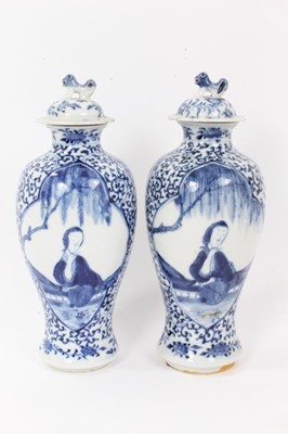 Lot 8 - Pair 19th century Chinese blue and white porcelain baluster vases and cover, decorated with figural panels on a foliate patterned ground